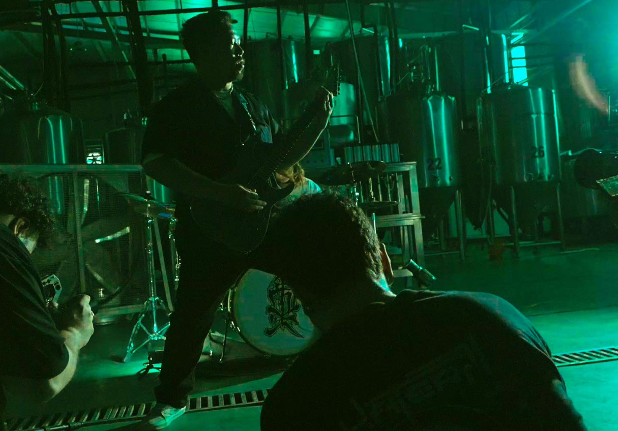 Guitarist performing with green lighting
